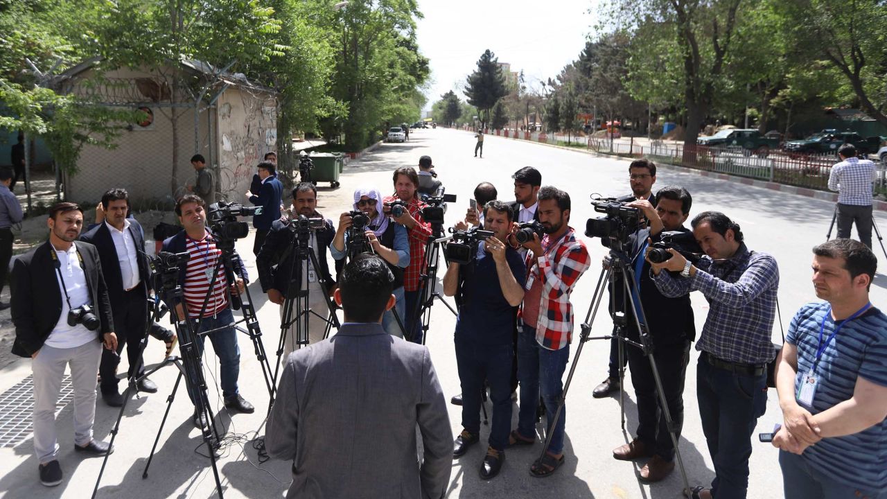 An official briefs journalists at the scene of the blasts in Kabul on Monday.