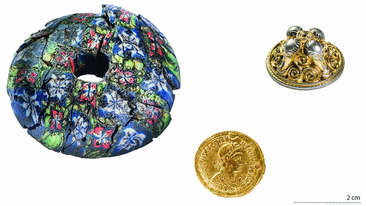 A large millefiori glass sword bead, a Valentinian III solidus (Roman coin) and a gilded silver sword pendant found on the floor of one of the homes.
