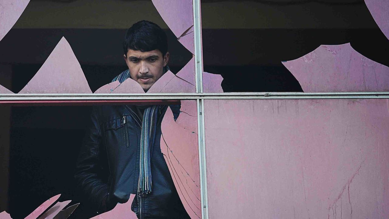 A man looks through a broken window at the site of a suicide attack in Kabul in January 2014.