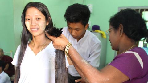 A woman has her hair cut in Yangon, Myanmar. 