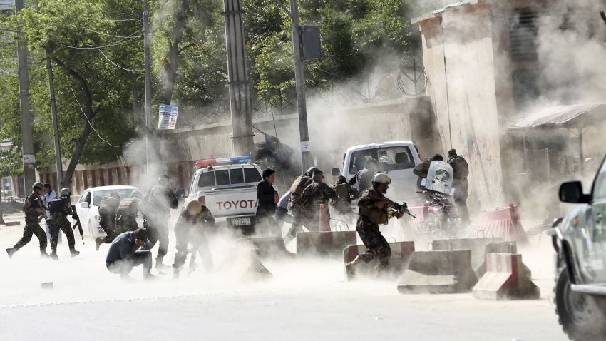 Security forces run from the site of a suicide attack after the second bombing in Kabul, Afghanistan, Monday, April 30, 2018. A coordinated double suicide bombing hit central Kabul on Monday morning, (AP Photo/Massoud Hossaini)