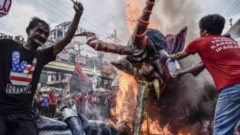 Workers burn an effigy of President Rodrigo Duterte as part of demonstrations outside the presidential palace in the capital Manila.