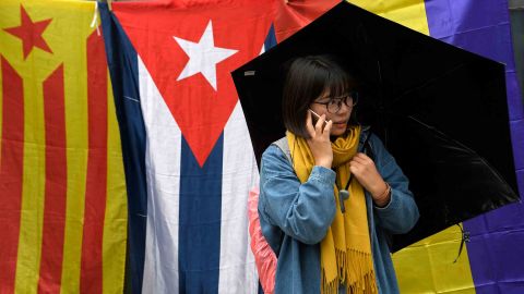 A woman is surrounded by a mixture of Catalonian and Spanish flags, at a rally in Barcelona.