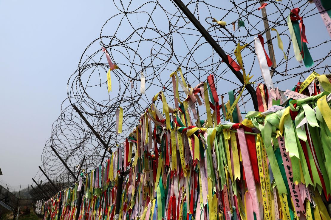 Civilians covered a barbed-wire fence with prayer ribbons near the DMZ.