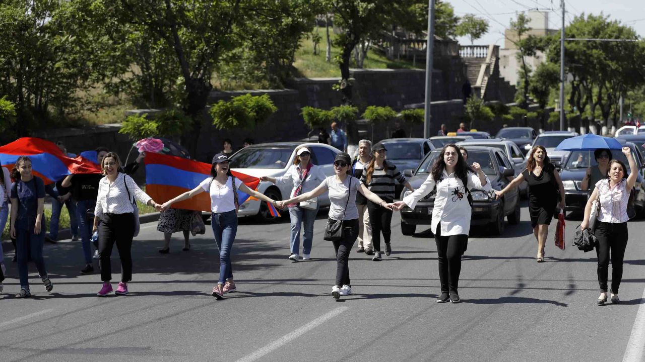 Supporters of the opposition lawmaker Nikol Pashinyan walk in front of cars as they block a road in Yerevan on May 2.