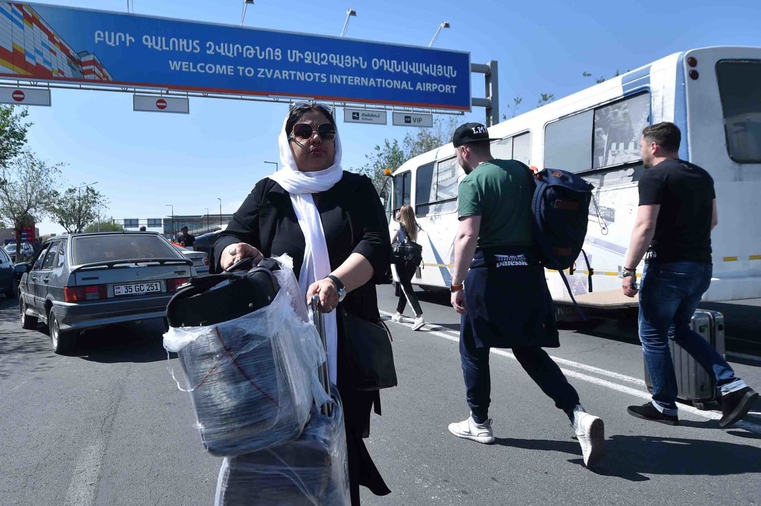 Passengers carry their luggage past protesters blocking a road to the airport on Wednesday. 