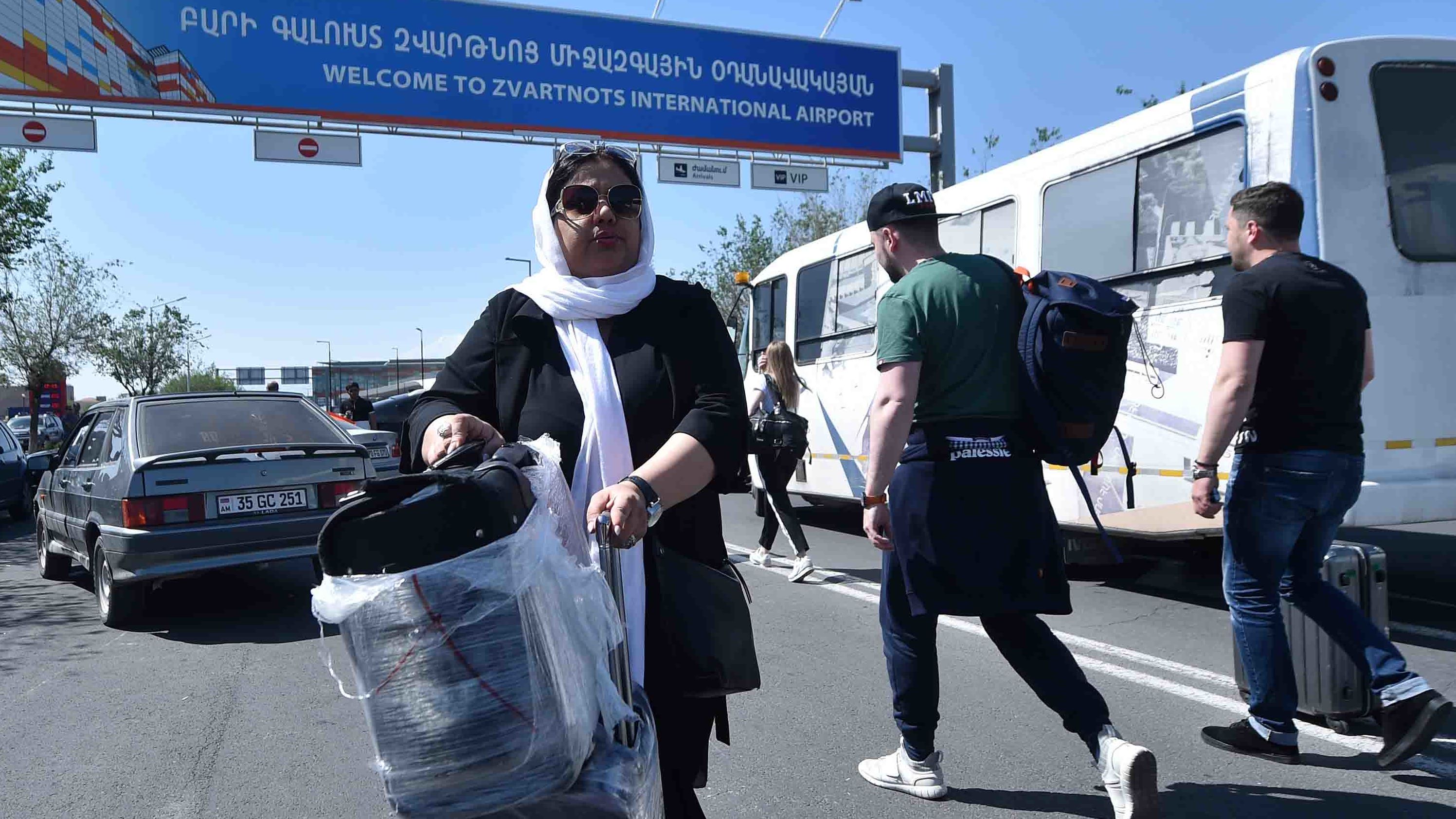 Passengers carry their luggage past protesters blocking a road to the airport on Wednesday. 