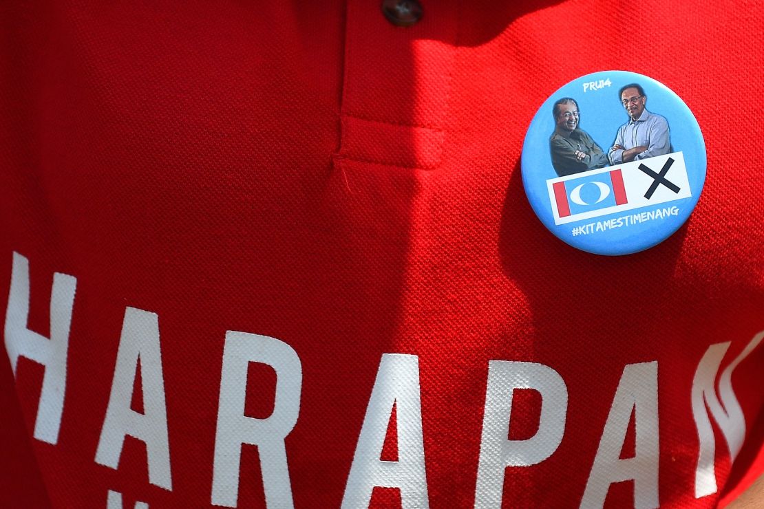 A supporter wears a badge with photographs of former Malaysian prime minister and opposition party Pakatan Harapan's prime ministerial candidate Mahathir Mohamad and jailed former opposition leader Anwar Ibrahim.