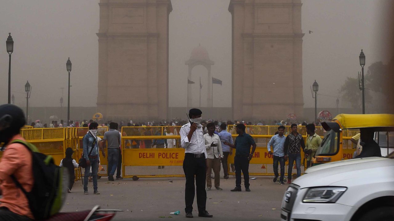 An Indian traffic policeman covers his face as he stands on duty in New Delhi.