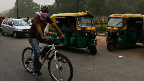 A man covers his face as he cycles during a dust storm in New Delhi, May 2.