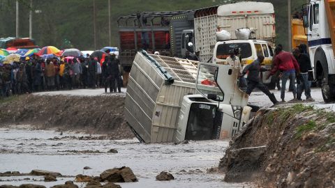 A man climbs off a truck that was washed off a road by flash floods in Isinya, about 58 km southeast of Nairobi, on March 15, 2018.