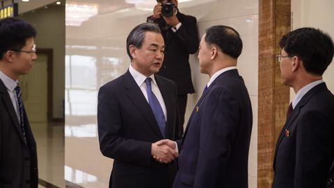 China's foreign minister Wang Yi (centre L) shakes hands with North Korea's vice foreign minister Ri Kil Song (centre R) at Pyongyang international airport on May 2.