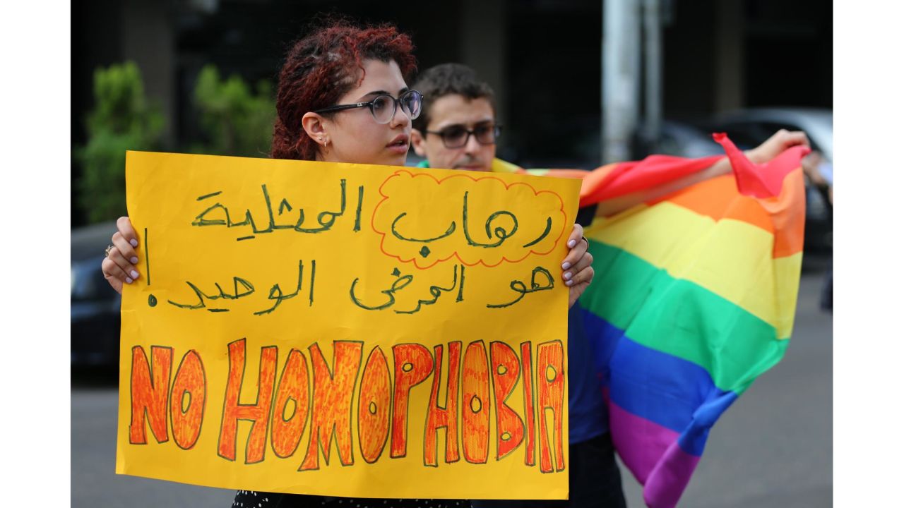 Supporters of the LGBT community protest the criminalization of homosexuality outside a Beirut police station in 2016. The Arabic writing reads: "The only disease is homophobia."