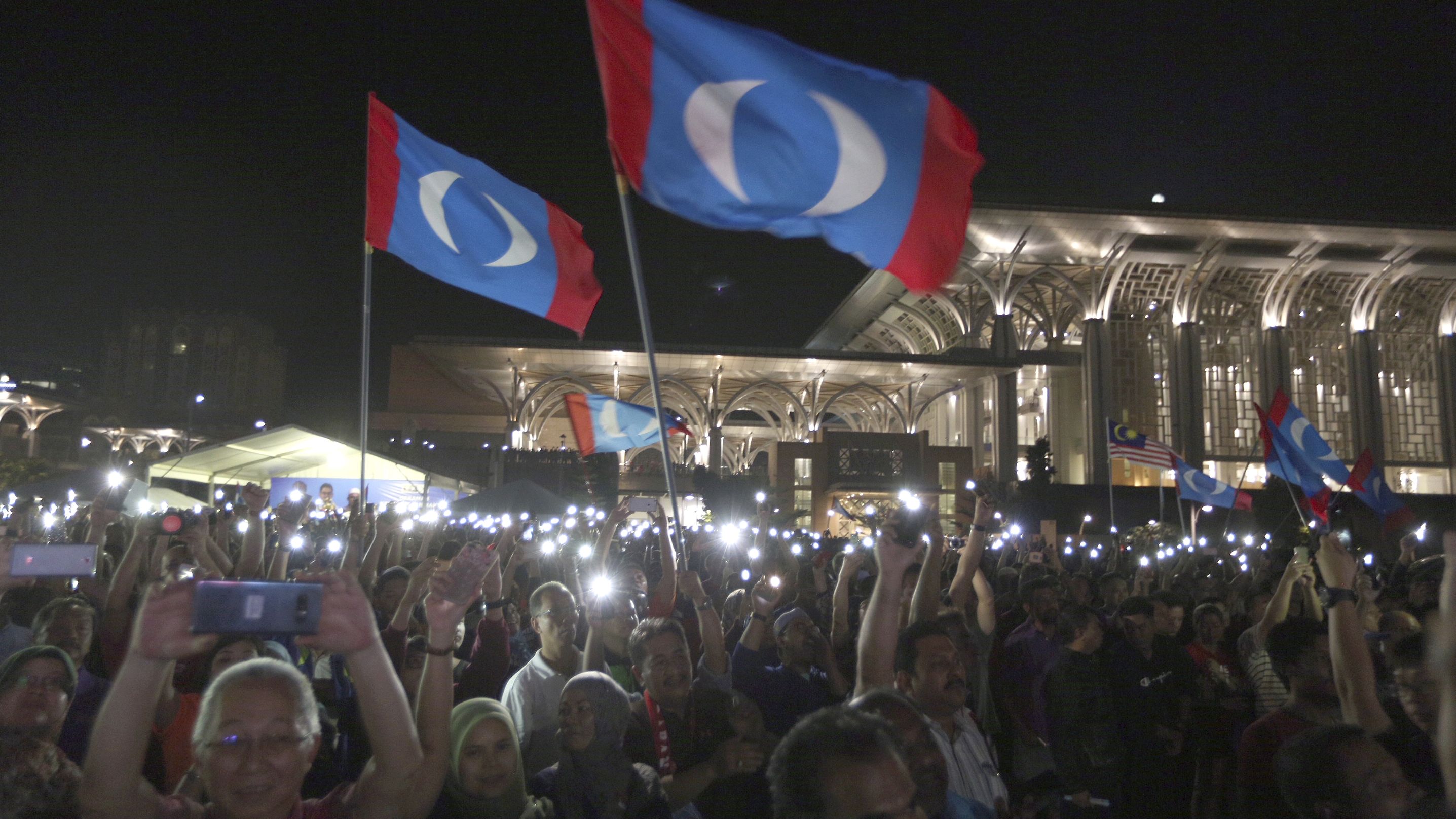 Supporters wave opposition party flags during an election campaign rally organized by Mahathir Mohamad, Putrajaya, Malaysia, May 3.