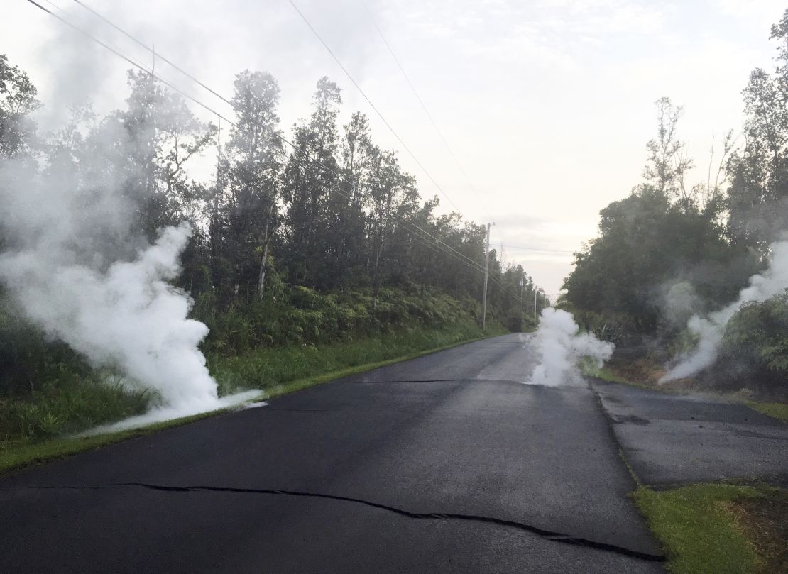 Steam rises Friday from cracks in a road near Leilani Estates on Hawaii's Big Island.