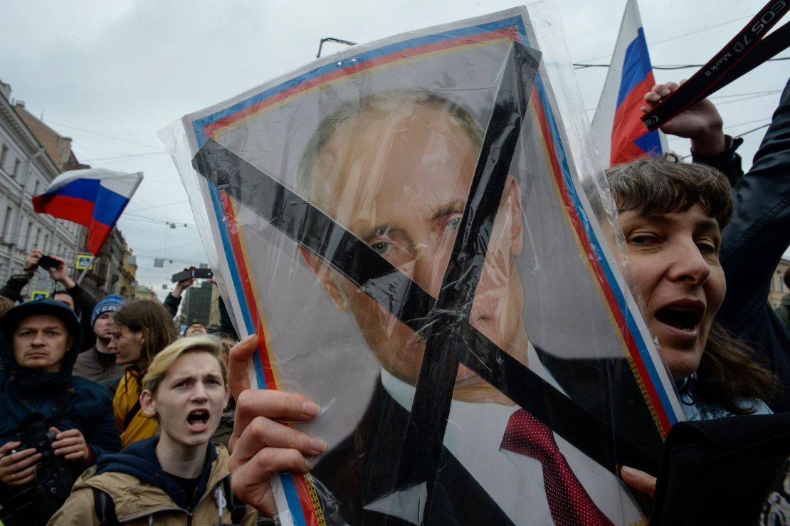 Protesters hold placards of Russian President Vladimir Putin during Saturday's rally.