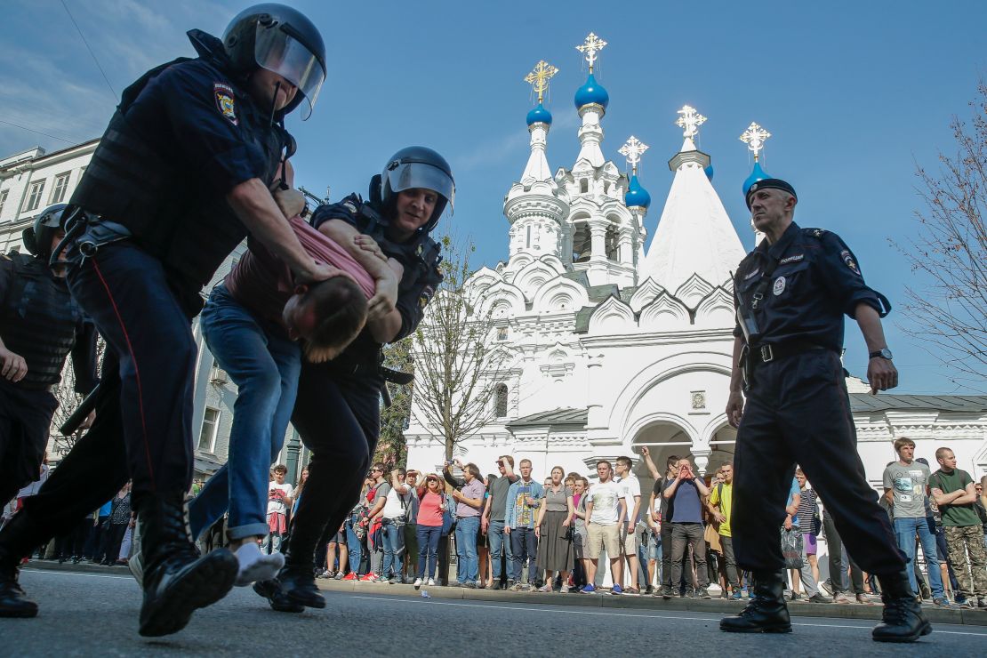 Russian police officers detain a protester.
