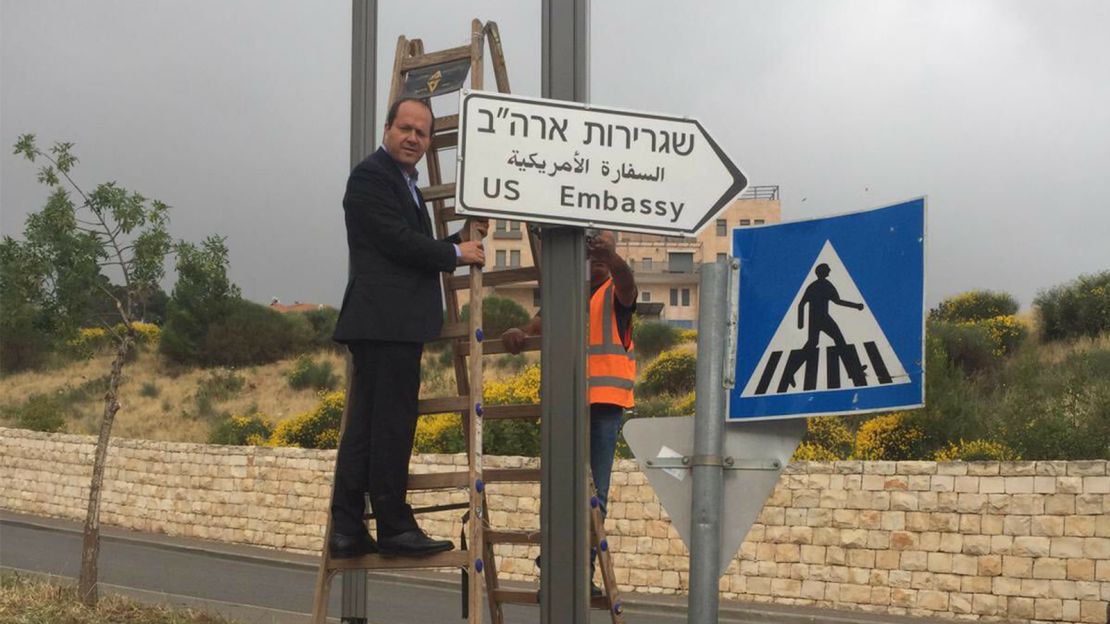Jerusalem Mayor Nir Barakat poses next to the newly erected road sign. 