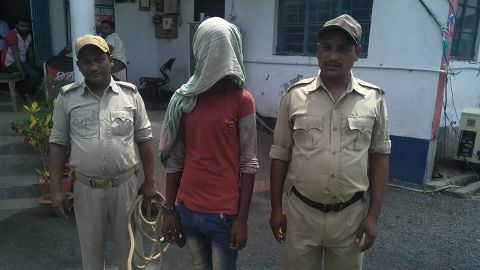 A suspect (C) being held by Indian police in the case of a 17-year-old girl who was raped and set on fire.