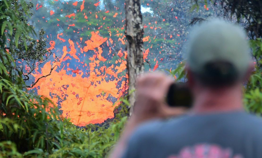 A man watches as lava spews from a fissure in the Leilani Estates subdivision near Pahoa, Hawaii.