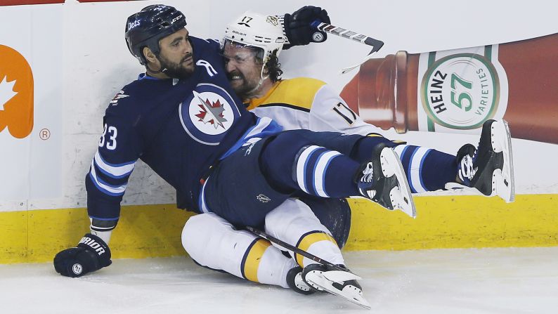 Winnipeg's Dustin Byfuglien, left, and Nashville's Scott Hartnell become better acquainted after colliding during Game 4 of their NHL playoff series on Thursday, May 3.