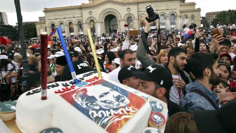 Supporters of Pashinyan carry a cake showing his face at a gathering in central Yerevan Tuesday.