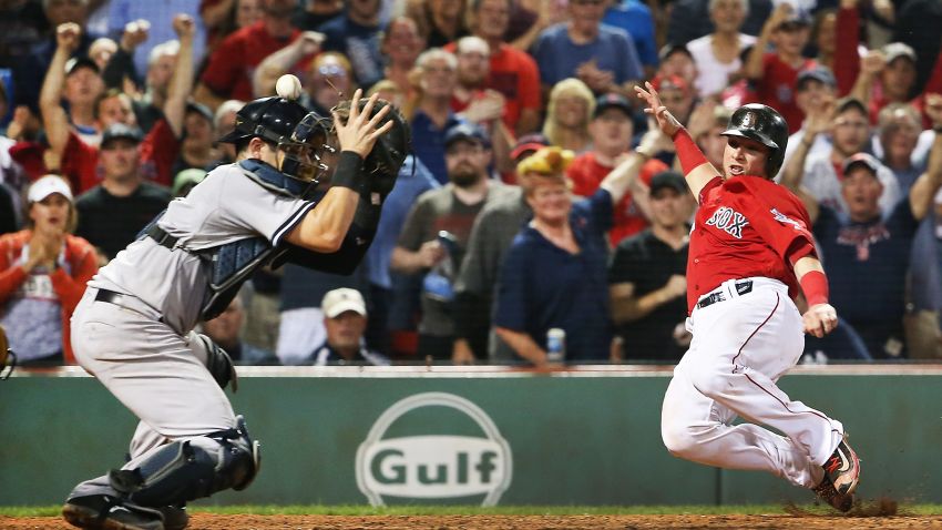 BOSTON, MA - AUGUST 18:  Christian Vazquez #7 of the Boston Red Sox slides safely into home as the throw bounces off the helmet of Austin Romine #27 of the New York Yankees in the eighth inning of a game at Fenway Park on August 18, 2017 in Boston, Massachusetts.  (Photo by Adam Glanzman/Getty Images)