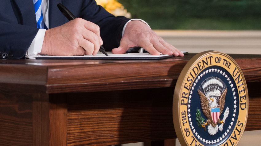 US President Donald Trump signs a document reinstating sanctions against Iran after announcing the US withdrawal from the Iran Nuclear deal, in the Diplomatic Reception Room at the White House in Washington, DC, on May 8, 2018. (Photo by Saul LOEB / AFP) / ALTERNATIVE CROP (Photo credit should read SAUL LOEB/AFP/Getty Images)