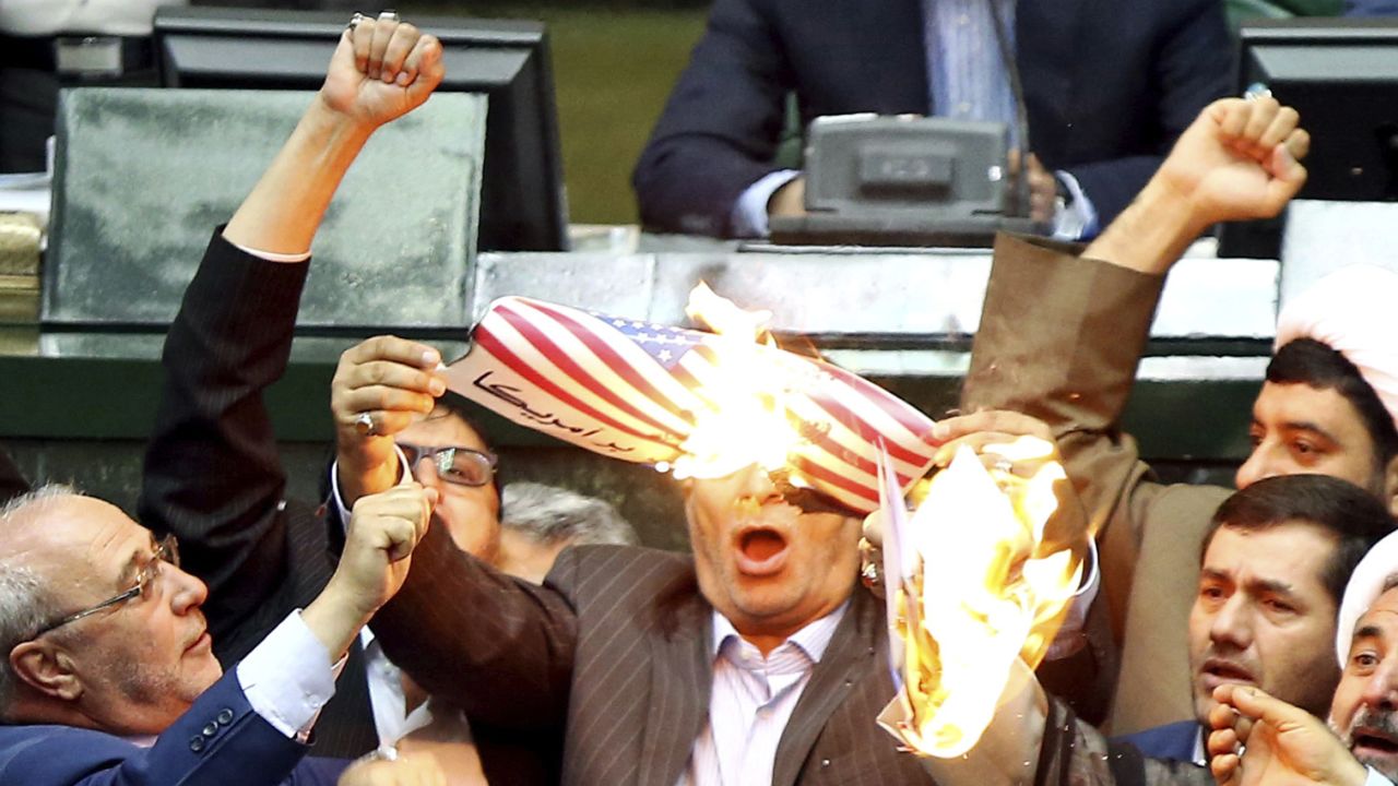 Iranian lawmakers burn two pieces of papers representing the U.S. flag and the nuclear deal as they chant slogans against the U.S. at the parliament in Tehran, Iran, Wednesday, May 9, 2018. Iranian lawmakers have set a paper U.S. flag ablaze at parliament after President Donald Trump's nuclear deal pullout, shouting, "Death to America!". President Donald Trump withdrew the U.S. from the deal on Tuesday and restored harsh sanctions against Iran. (AP Photo)