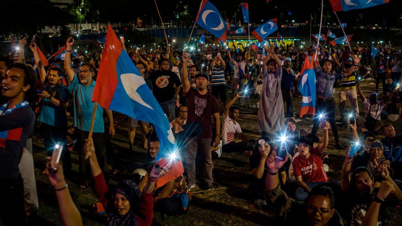 Supporters of Mahathir Mohamad cheer as they watch live televised result announcement in Kuala Lumpur.