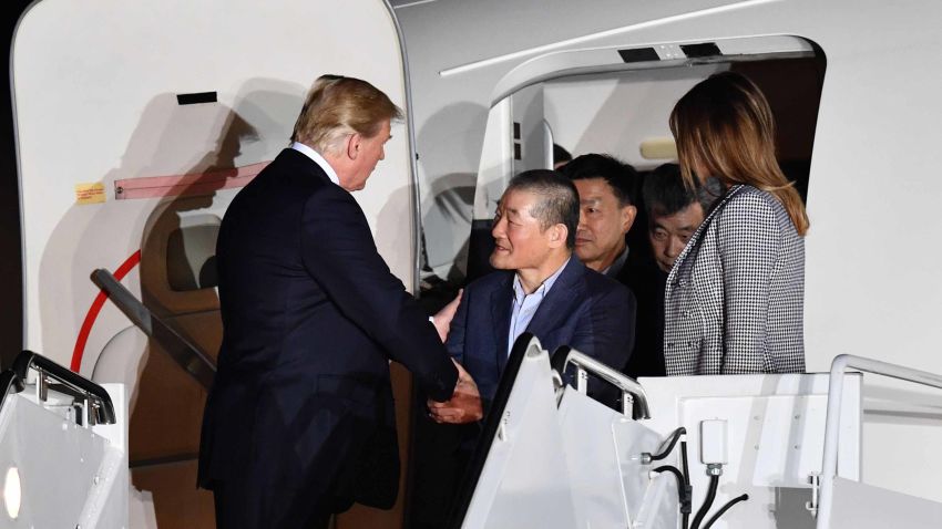 US President Donald Trump (L) shakes hands with US detainee Kim Dong-chul (C) upon his return with fellow detainees Kim Hak-song and Tony Kim (behind) after they were freed by North Korea, at Joint Base Andrews in Maryland on May 10, 2018. - US President Donald Trump greeted the three US citizens released by North Korea at the air base near Washington early on May 10, underscoring a much needed diplomatic win and a stepping stone to a historic summit with Kim Jong Un. (Photo by Nicholas Kamm / AFP)        (Photo credit should read NICHOLAS KAMM/AFP/Getty Images)