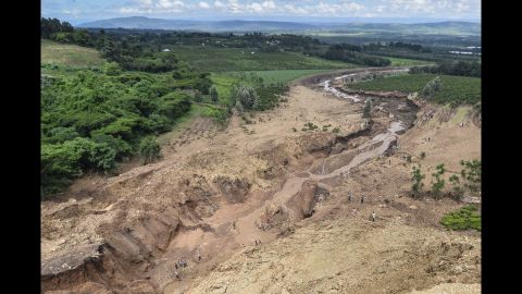 People survey the area of erosion caused by the flood. According to Lee Kinyanjui, the governor of Nakuru County, those affected by the dam are "mostly workers and small-scale farmers."
