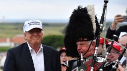 AYR, SCOTLAND - JUNE 24:  A bagpipe player wears traditional dress next to Presumptive Republican nominee for US president Donald Trump as he arrives to his Trump Turnberry Resort on June 24, 2016 in Ayr, Scotland. Mr Trump arrived to officially open his golf resort which has undergone an eight month refurbishment as part of an investment thought to be worth in the region of two hundred million pounds.  (Photo by Jeff J Mitchell/Getty Images)