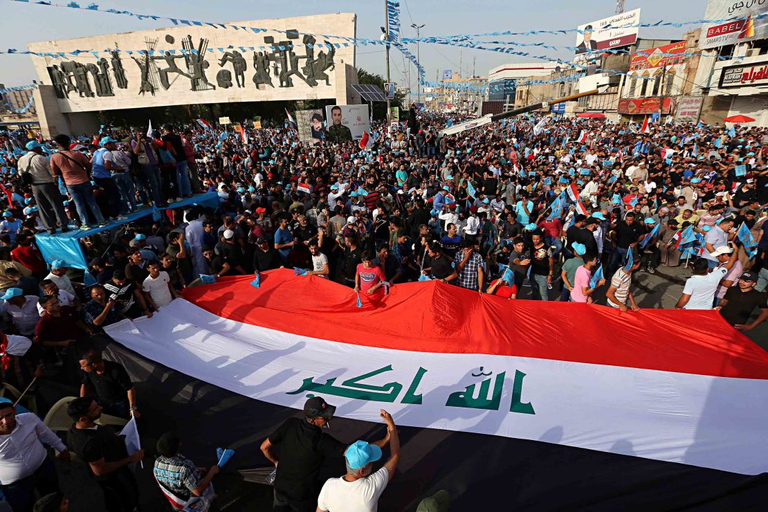 Followers of Shiite cleric Muqtada al-Sadr carry a huge Iraqi flag as they take part in a campaign rally in Baghdad on May 4.