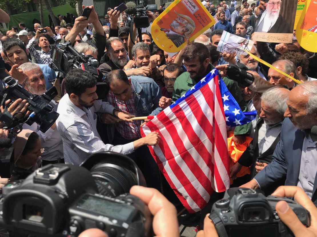 Protesters prepare to burn a US flag at a demonstration in Tehran.