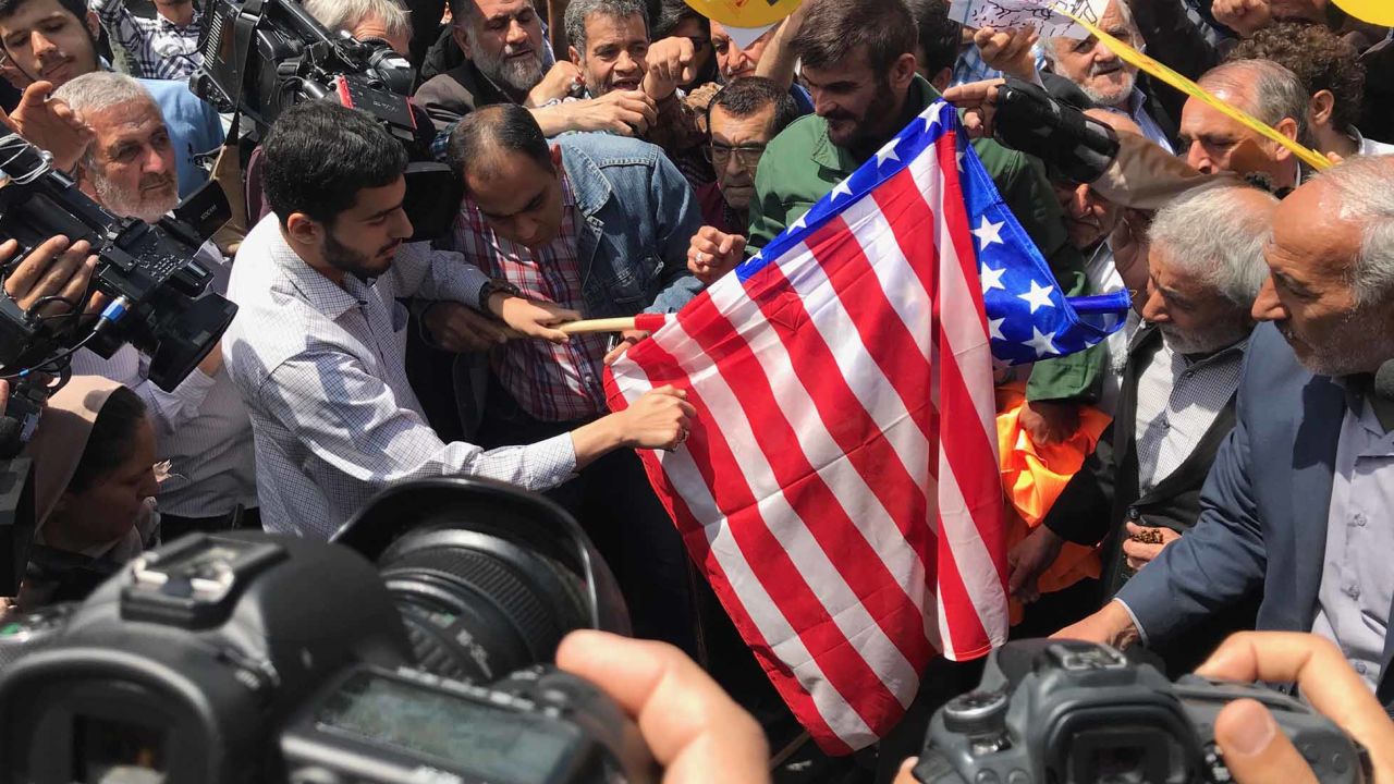 Protesters prepare to burn a US flag at a demonstration in Tehran.