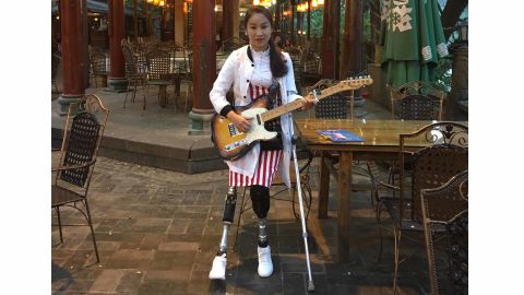 Li Yingxia, Sichuan earthquake survivor, on her artificial limbs with her guitar prior to one of her public singing events.