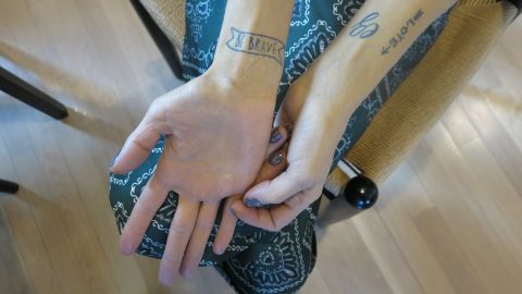 The tattoo on Erika's right rist reads, "Be brave."