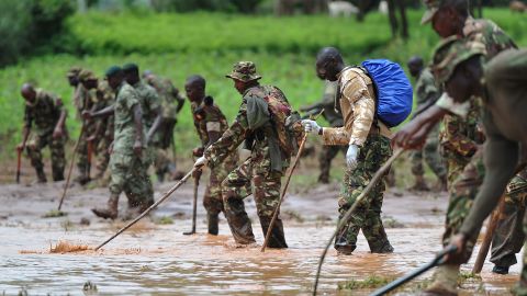 Kenyan soldiers search through mud and debris on Friday, May 11.
