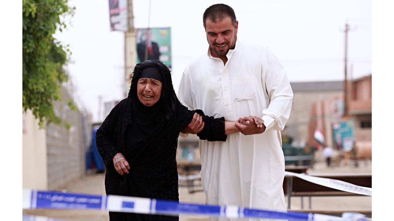 An Iraqi elderly woman is helped by her son as she prepares to casts her ballot in the country's parliamentary elections in Ramadi, Iraq, Saturday, May 12, 2018. 