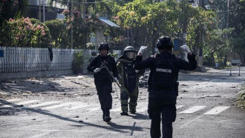 Indonesian bomb squad members examine the site following a suicide bombing outside a church in Surabaya early Sunday.