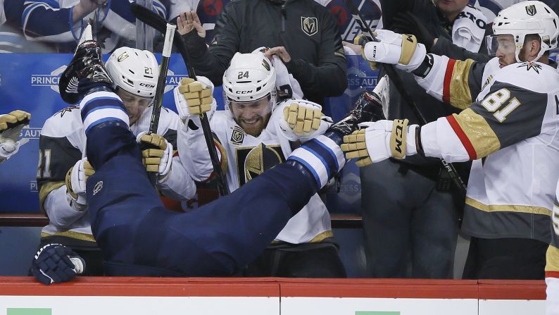 Winnipeg Jets' Blake Wheeler gets dumped over the boards by Vegas Golden Knights' Ryan Reaves, not seen, in front of Cody Eakin (21), Oscar Lindberg (24) and Jonathan Marchessault (81) during the first period of Game 1 of the NHL hockey playoffs Western Conference Final on Saturday, May 12, in Winnipeg, Manitoba. 