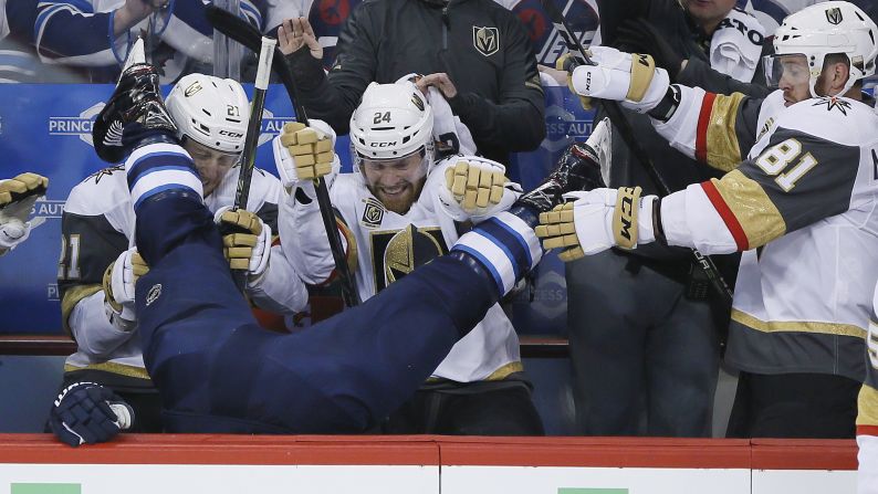 Winnipeg Jets' Blake Wheeler gets dumped over the boards by Vegas Golden Knights' Ryan Reaves, not seen, in front of Cody Eakin (21), Oscar Lindberg (24) and Jonathan Marchessault (81) during the first period of Game 1 of the NHL hockey playoffs Western Conference Final on Saturday, May 12, in Winnipeg, Manitoba.