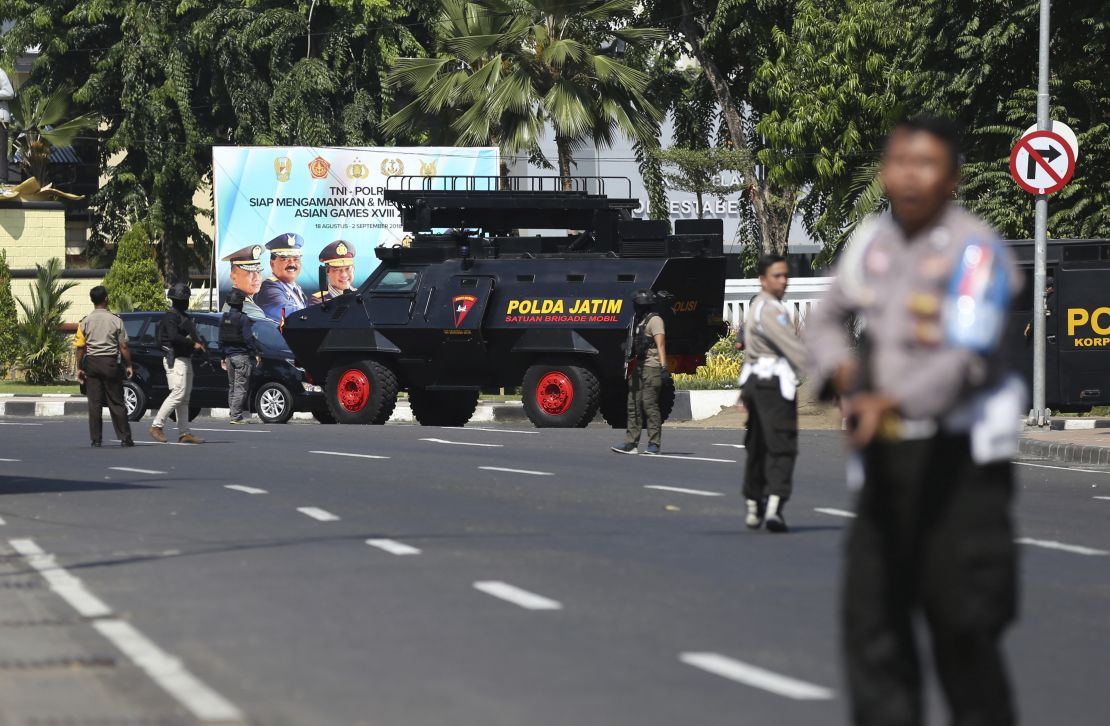 Officers block a road following an attack at the local police headquarters in Surabaya, East Java, Indonesia.