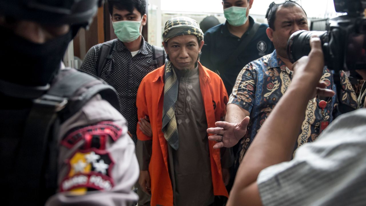 Indonesian armed police escort Indonesian radical cleric Aman Abdurrahman (C) into the South Jakarta courtroom in Jakarta on February 15, 2018.