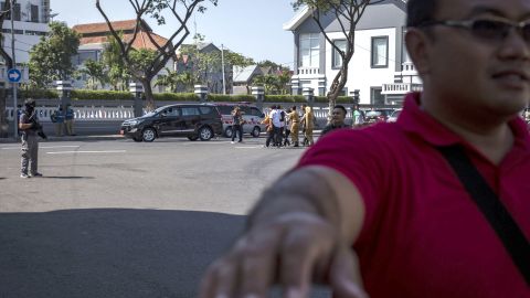 Surabaya's mayor Tri Risma Harini being evacuated away as Indonesian police stand guard outside the Surabaya police station following another explosion.