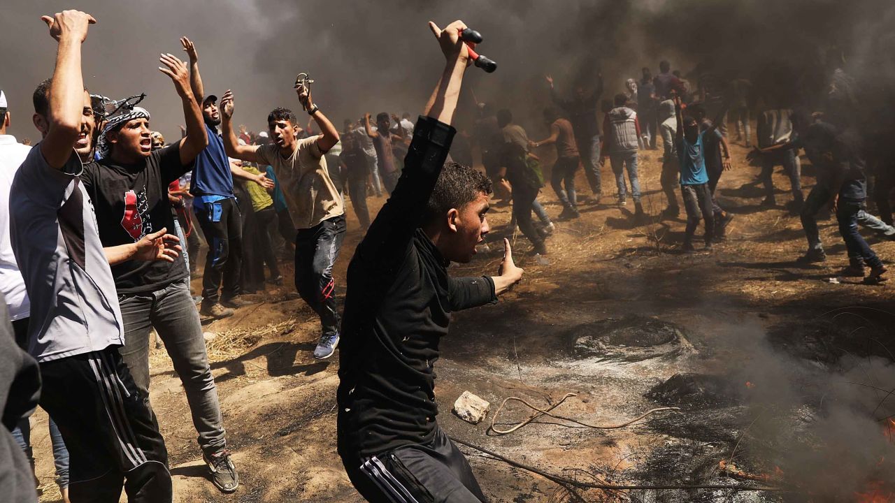 Palestinians rush to the border fence with Israel as mass protests take place on May 14 in Gaza City.