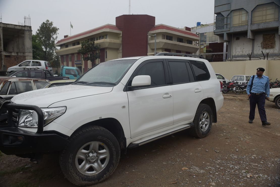 A Pakistani policeman walks past a car of an American diplomat parked inside a police station after an accident in Islamabad on April 8, 2018.