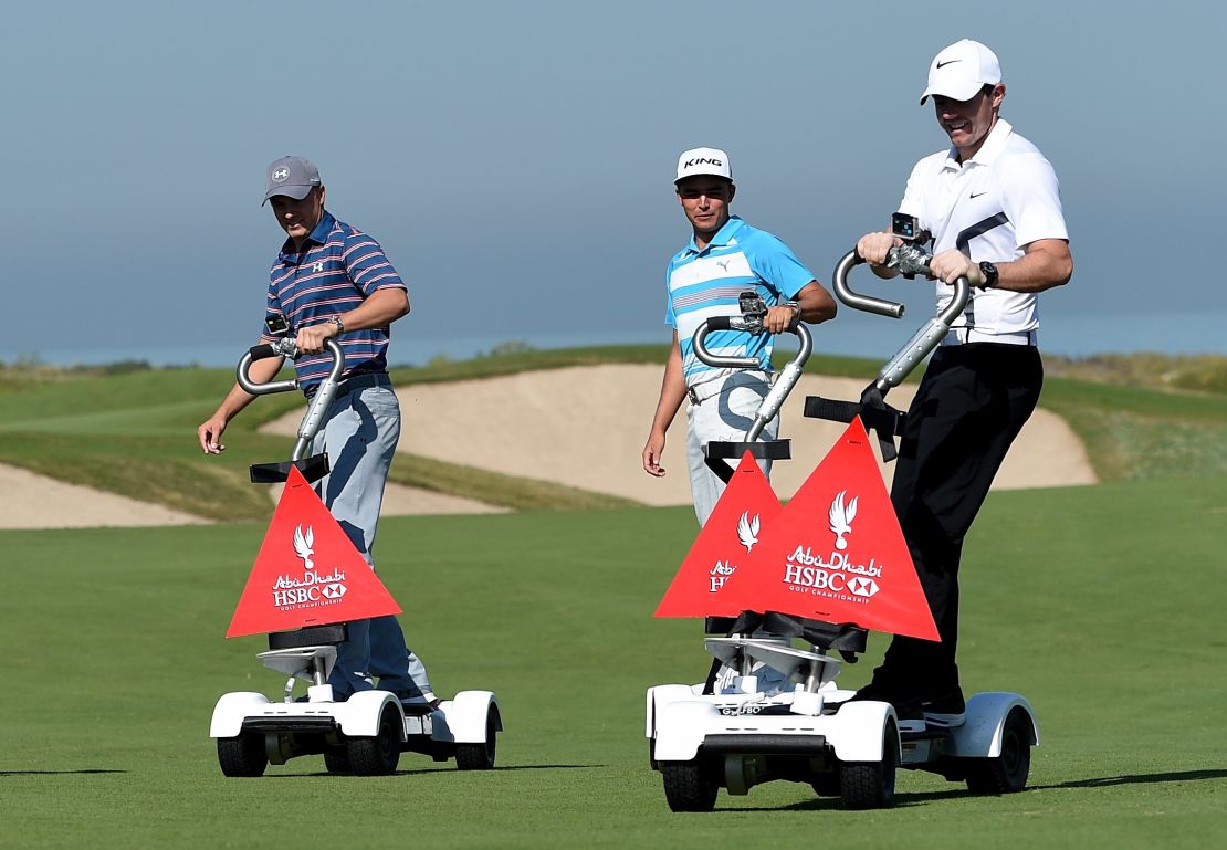 Jordan Spieth (left) rides a golfboard with Rickie Fowler (center) and Rory McIlroy in Abu Dhabi.