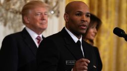  U.S. Surgeon General Jerome Adams (2nd L) speaks as President Donald Trump (L) and first lady Melania Trump (R) look on during a reception in the East Room of the White House February 13, 2018 in Washington, DC. President Trump and the first lady hosted a reception to celebrate the National African American History Month with leaders and representatives from the African American community.  (Photo by Alex Wong/Getty Images)